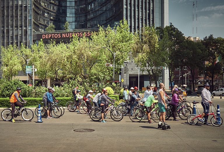 Grupo de ciclistas detenidos en un cruce urbano de Ciudad de México durante una ruta en bicicleta