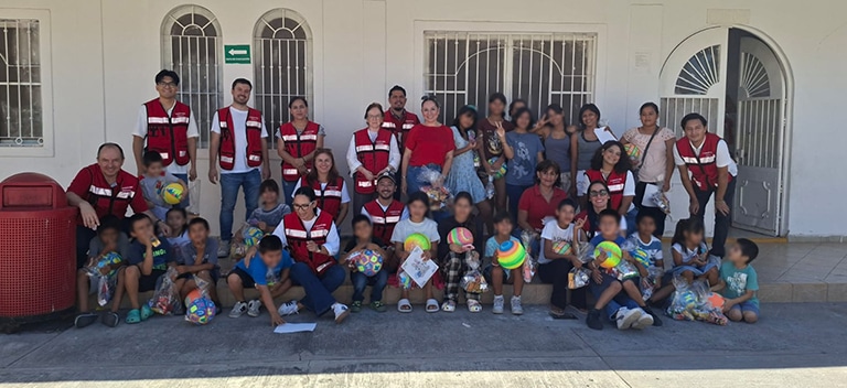 Voluntarios compartiendo una jornada recreativa con niños y familias en un centro comunitario.