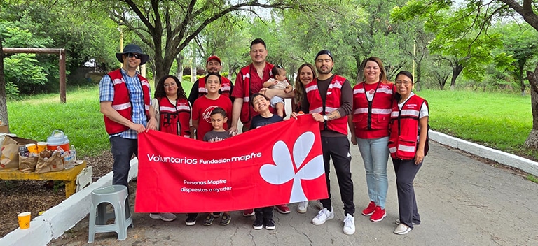 Grupo de voluntarios junto a familias durante una jornada solidaria al aire libre en México.