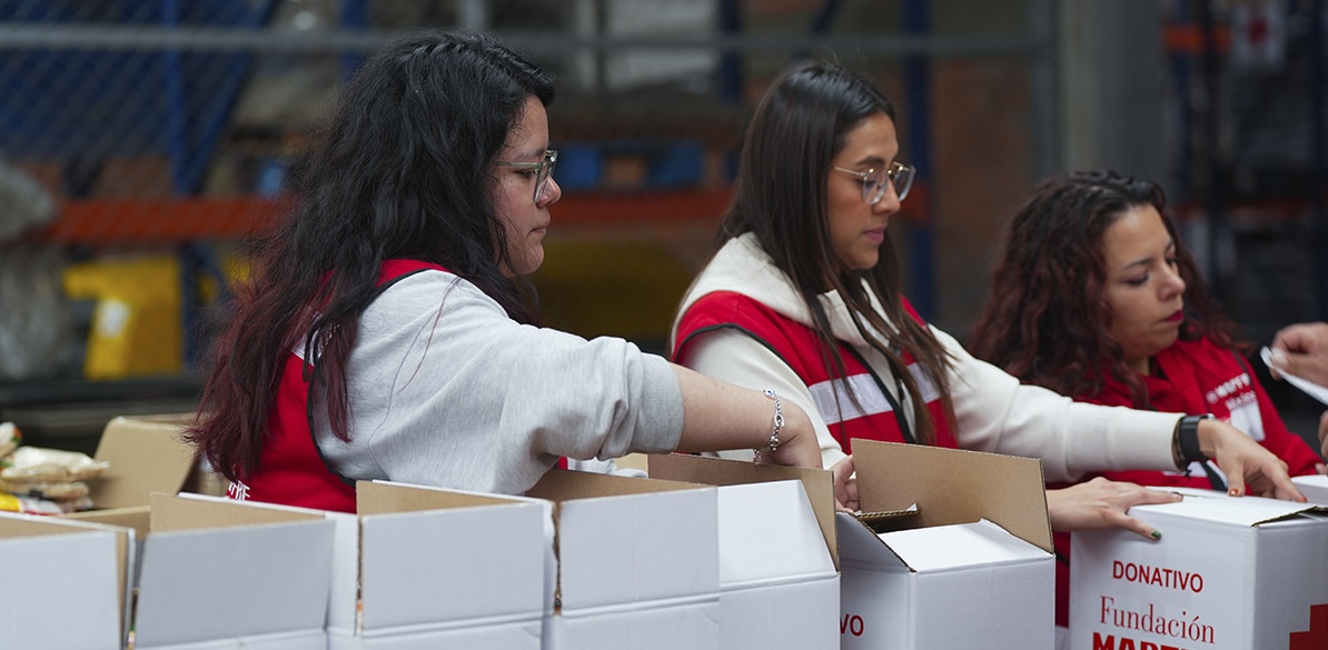 Todos con Veracruz Tres voluntarias con chalecos de Cruz Roja preparando cajas de donativo de Fundación Mapfre en un centro logístico durante la emergencia por las inundaciones de Veracruz 2025