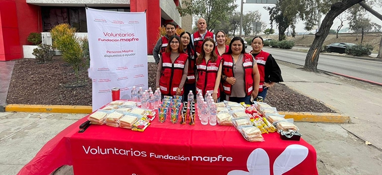 Voluntarios preparando y distribuyendo alimentos y agua para personas en situación vulnerable.