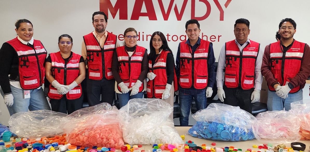 Voluntarios de Fundación Mapfre México con chalecos rojos clasificando tapones de plástico para reciclaje