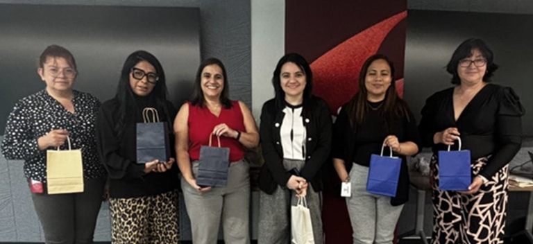 Grupo de mujeres compartiendo un momento especial por el Día de las Madres en un entorno profesional