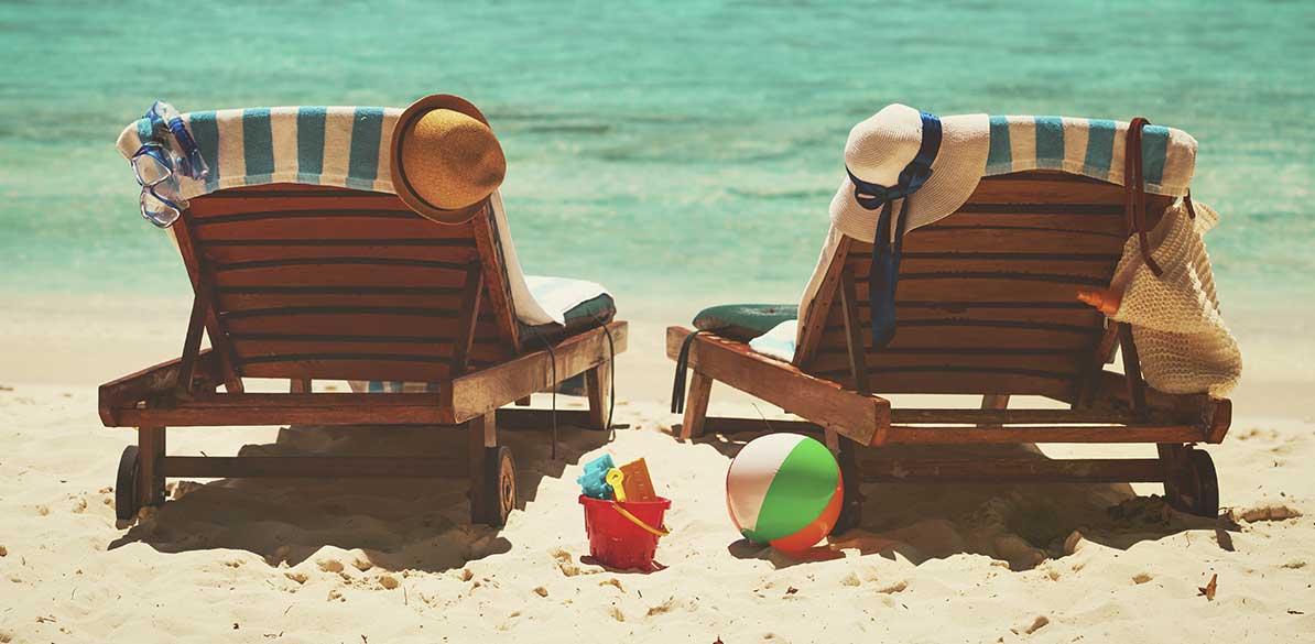 Tumbonas en la playa con sombreros junto al mar durante las vacaciones de verano
