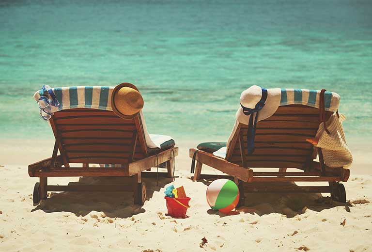 Tumbonas en la playa con sombreros junto al mar durante las vacaciones de verano