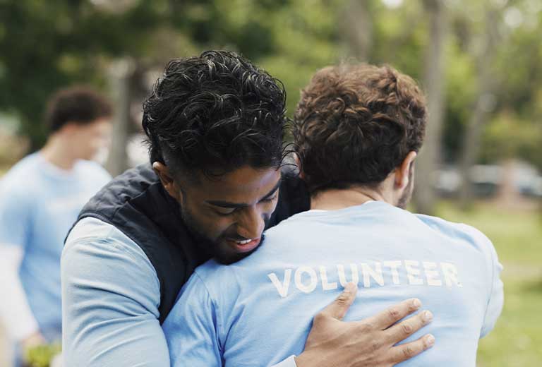 Voluntarios de Fundación Mapfre abrazándose durante una jornada de acción social.